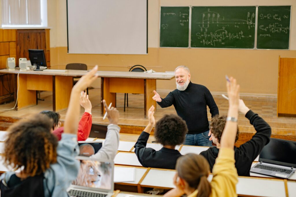Professor and students interacting in lecture hall.