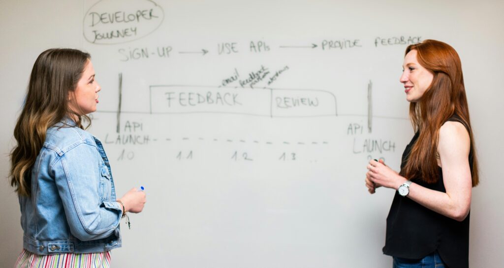 Two women in front of a classroom whiteboard